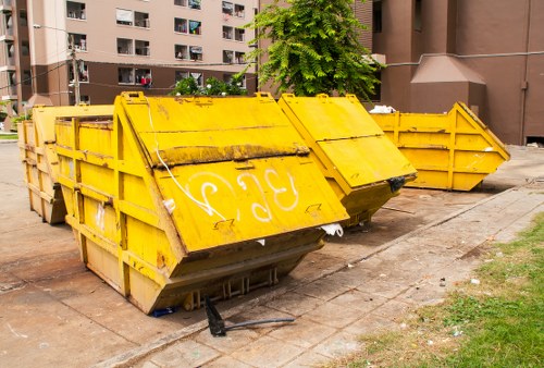 Front view of a Hayes Skip Hire vehicle and workers coordinating delivery